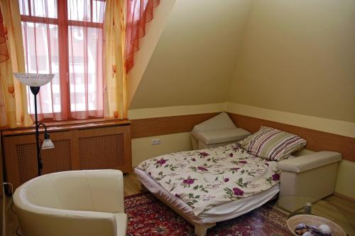 a small room with a bed and a bath tub at Villa Sakura Panzió in Sopron