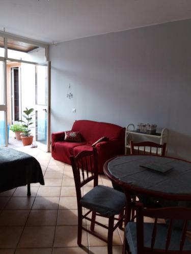 a living room with a red couch and a table at For Ever Apartments in Fiumicino