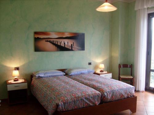 オッジェッビオにあるCasa Coccinellaのベッドルーム1室(壁に絵画が描かれたベッド1台付)
