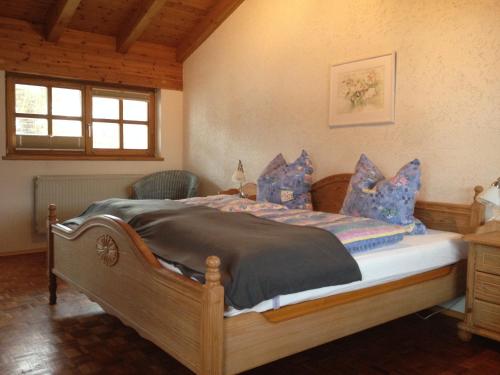 レーゲンにあるFerienwohnung Weinbergerのベッドルーム(青い枕の大型ベッド1台付)