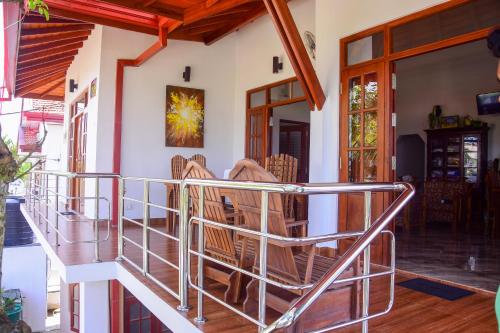 a porch of a house with chairs and a staircase at Channa Villa & Tours in Bentota
