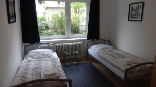 2 Betten in einem Zimmer mit Fenster in der Unterkunft Monteurzimmer - Messe Nord in Hannover