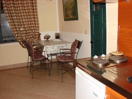 a dining room with a table and chairs in a kitchen at Zoro Apartments in Sveti Stefan