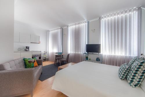 ポルトにあるCitybreak-apartments Coliseuのベッドルーム1室(ベッド1台、ソファ、テーブル付)