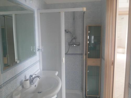 uma casa de banho branca com um lavatório e um chuveiro em Attico Ostuni em Ostuni