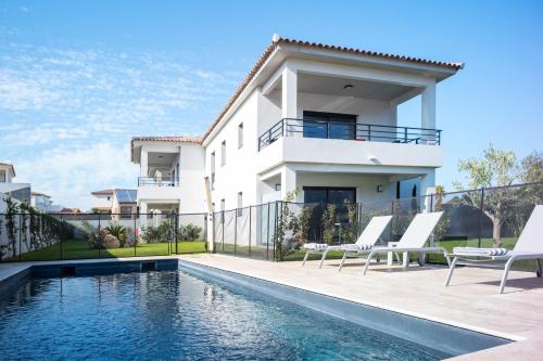 une maison avec une piscine devant une maison dans l'établissement Residence Petradoru, à LʼÎle-Rousse