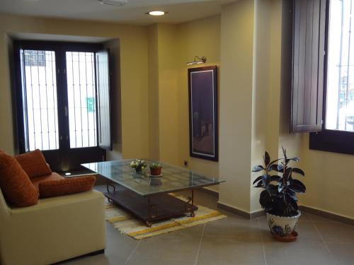 a living room with a glass table and a couch at Hotel Rural Real de Poqueira in Capileira