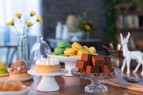 a table topped with cakes and other desserts on plates at Island Luxurious Suites Hotel and Spa in Netanya