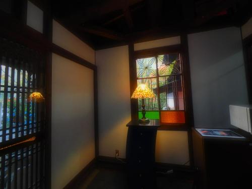 a corner of a room with a lamp and two windows at Kotohira Guest House en in Hita