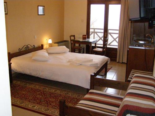 a bedroom with a large bed and a balcony at Guesthouse Kallisto in Kastaniá