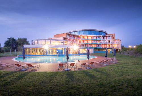 a large building with a pool in front of it at Kurzentrum Waren (Müritz) in Waren