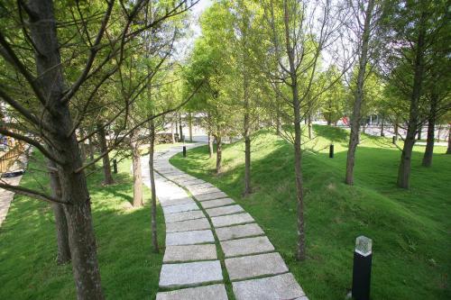 a path in a park with trees and grass at Xianel Vacation Chateau in Dahu