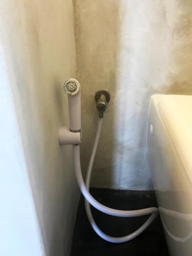 a hose hooked up to a toilet in a bathroom at Villa Huruma in Paje