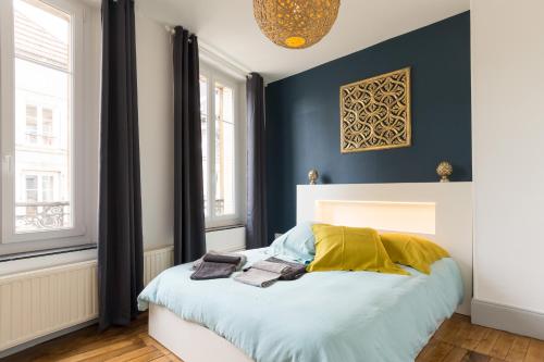 a bedroom with a bed with a blue wall at Suite Rimbaud in Charleville-Mézières