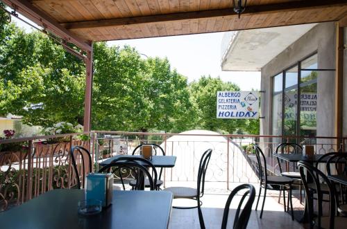 a patio with tables and chairs on a balcony at Holiday in Magliano deʼ Marsi