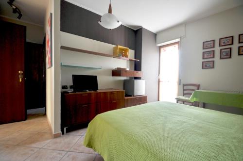 a bedroom with a green bed and a television at Al 32 y 3 in Alghero
