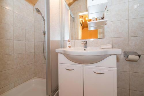 a white bathroom with a sink and a shower at Ferienwohnung DrauSport in Greifenburg