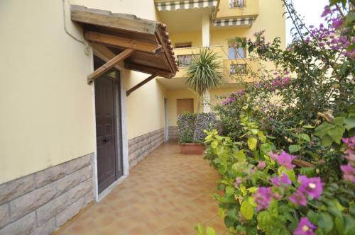 a courtyard of a house with a door and flowers at Al 32 y 3 in Alghero