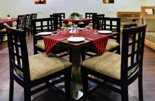 un comedor con una mesa con platos y vasos. en Regal Hotel, en Ajmer