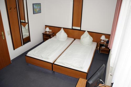 a bedroom with a bed with two pillows on it at Landhotel Pagram-Frankfurt/Oder in Frankfurt/Oder
