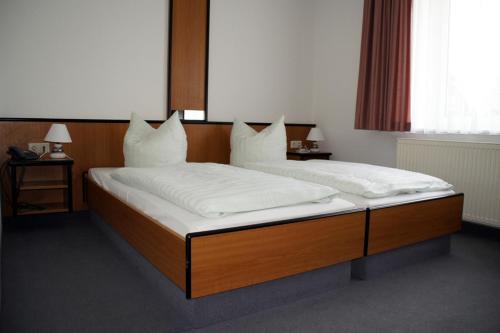 a bedroom with two beds with white pillows at Landhotel Pagram-Frankfurt/Oder in Frankfurt/Oder