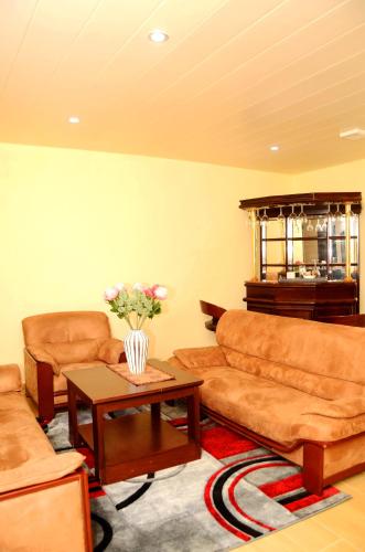 a living room with couches and a table with flowers at The Cape Hotel in Monrovia