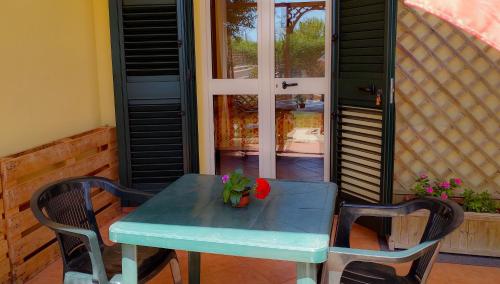 una mesa azul con dos sillas y un jarrón en ella en Bonjour, en Morciano di Leuca