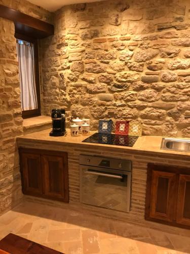 a kitchen with a stone wall and a stove at Mamihouse in Gubbio