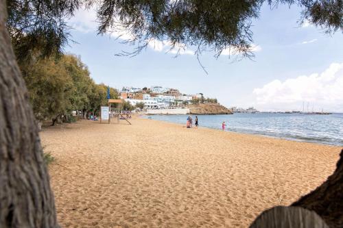 a sandy beach with people walking on it next to the water at Villa San Dimitrio House on the Beach in Logaras