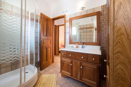 een badkamer met een bad, een wastafel en een spiegel bij Villa San Dimitrio House on the Beach in Logaras