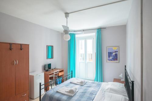 a bedroom with a bed with blue curtains and a window at Gialel B&B in Rome