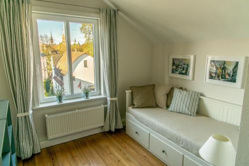 een woonkamer met een bank voor een raam bij Apartment Stadtblick in Lübeck