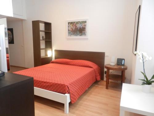 ラ・スペツィアにあるCentral Guesthouseのベッドルーム1室(赤い掛け布団付きのベッド1台付)