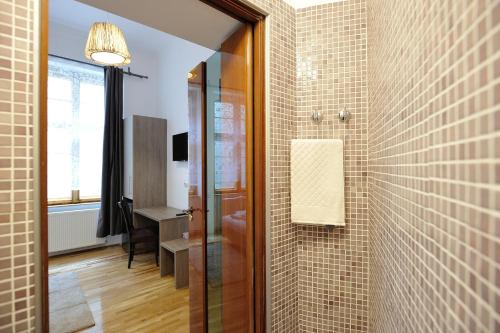 een badkamer met een douche en een tegelwand bij Dinicu Residence - Central Location in Braşov