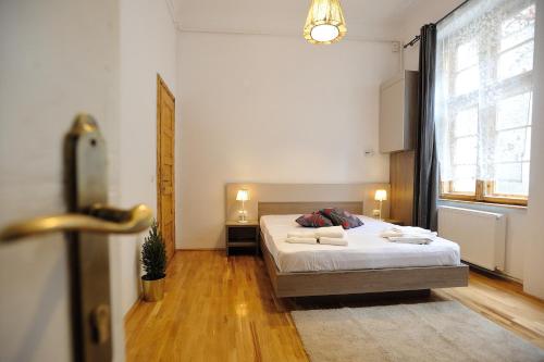 een slaapkamer met een bed en een groot raam bij Dinicu Residence - Central Location in Braşov