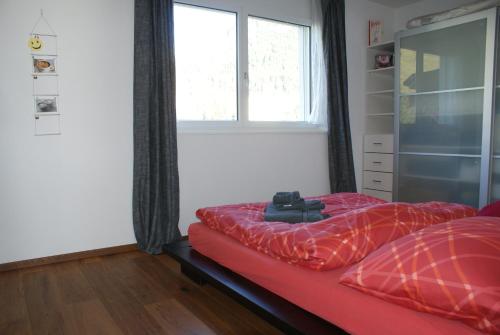 ダボスにあるBlumenauのベッドルーム1室(赤いベッド1台、窓付)