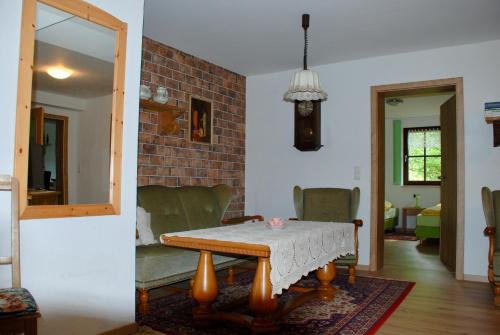 a living room with a table and a brick wall at Pension Tannenspitze in Lutherstadt Wittenberg