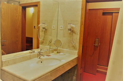 a bathroom with a sink and a mirror at Quinta do Louredo Hotel in Espinhel