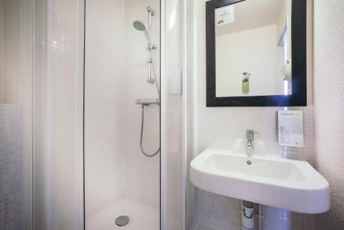 a white bathroom with a sink and a shower at Campanile Créteil Centre in Créteil