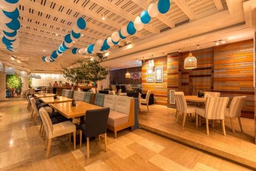 ein Restaurant mit Holzwänden und Tischen und Stühlen in der Unterkunft Hotel Tyulenovo in Tyulenovo