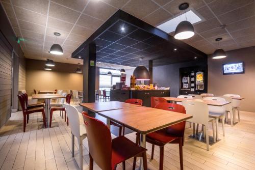 uma sala de jantar com mesas e cadeiras num restaurante em Campanile Créteil Centre em Créteil