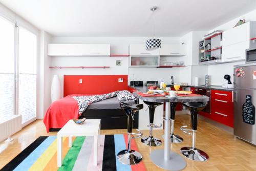 a red and white kitchen with a table in a room at ★★★Red Velvet Haven | Free garage+Bikes+Coffee★★★ in Ljubljana