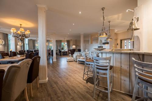 a kitchen and living room with a bar and chairs at Das 53°Hotel in Bad Zwischenahn