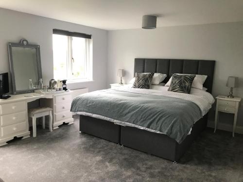 a bedroom with a bed and a sink and a mirror at Olcote House in Padstow