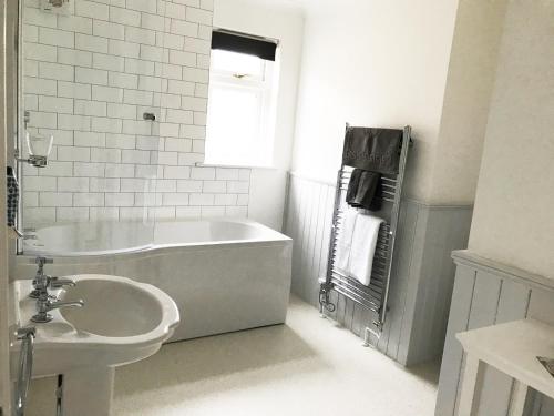uma casa de banho branca com uma banheira e um lavatório em Olcote House em Padstow