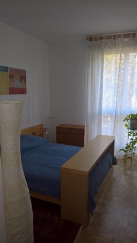 - une chambre avec un lit, une table et des rideaux dans l'établissement Appartement Meublé, à Garches