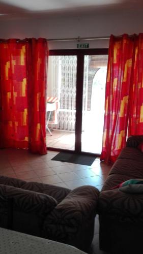 a living room with red curtains and a couch at Residences Abrico in Mont Choisy