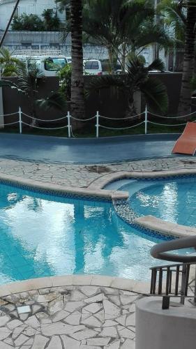 a swimming pool with blue water in a resort at Residences Abrico in Mont Choisy