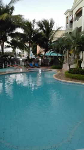 a large blue swimming pool with palm trees in the background at Residences Abrico in Mont Choisy