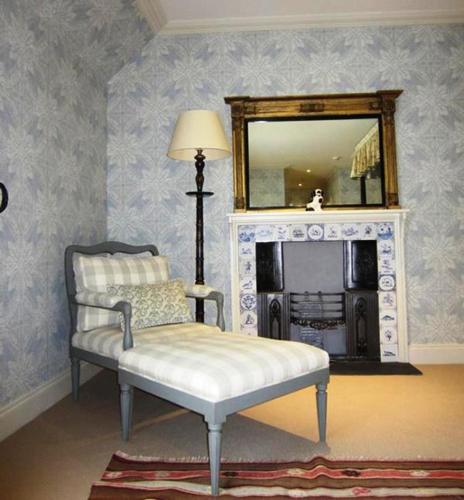 a living room with a chair and a mirror at The Loch Lomond Arms Hotel in Luss